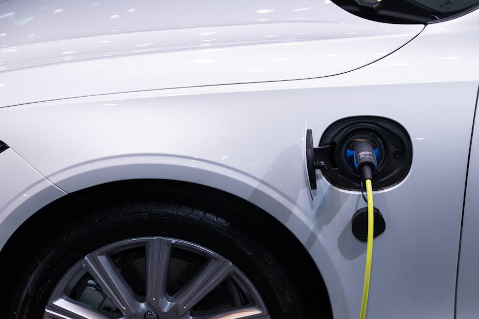 bobo_hybrid_car A white electric car is plugged in for charging, close-up view of the charging port.