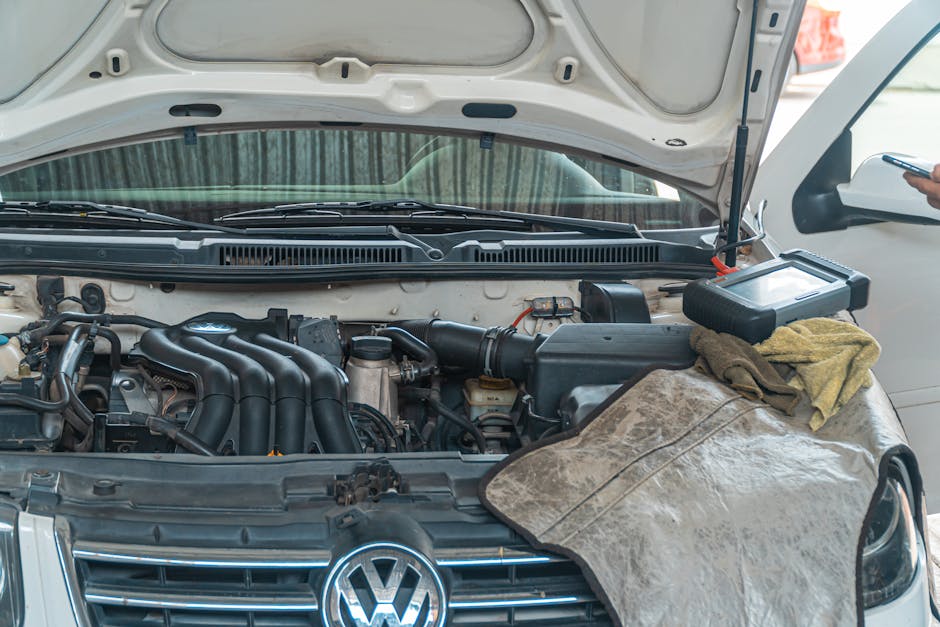 Close-up of a Volkswagen car engine undergoing repair in a garage, tools and diagnostic equipment in use.